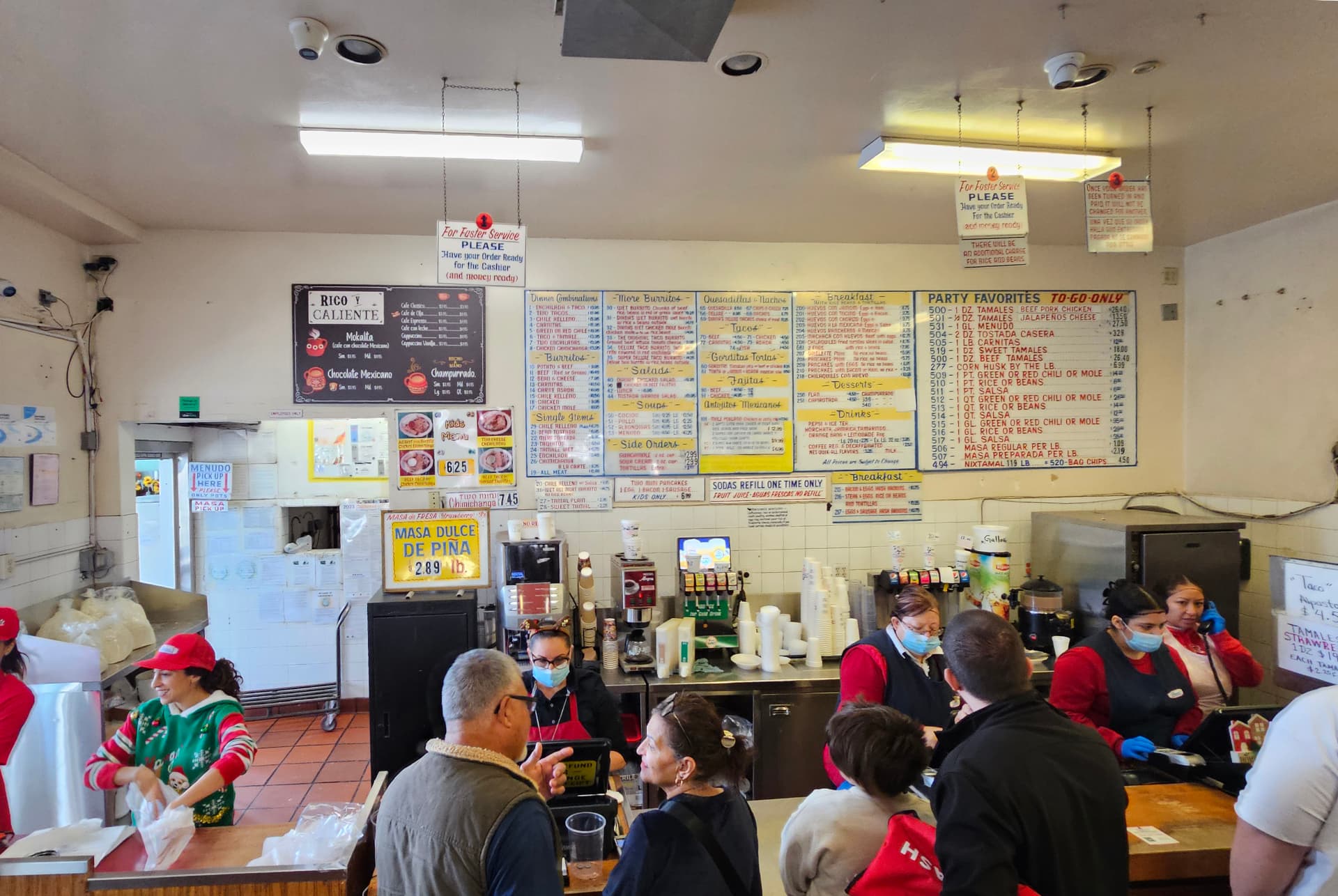 Customers at the Diana's counter beneath the classic hand-painted menu boards